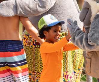 kid giving a high-five to Kalahari character