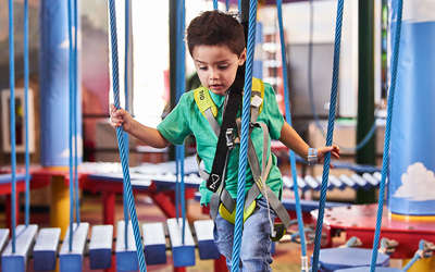 a little boy enjoying the ropes course at Tom Foolerys Adventure Park