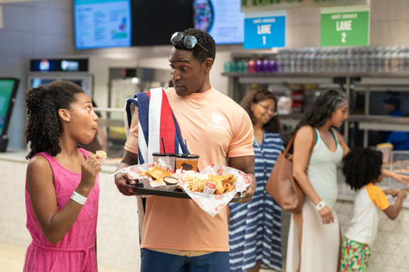 family walking with their tray full of kukus chicken