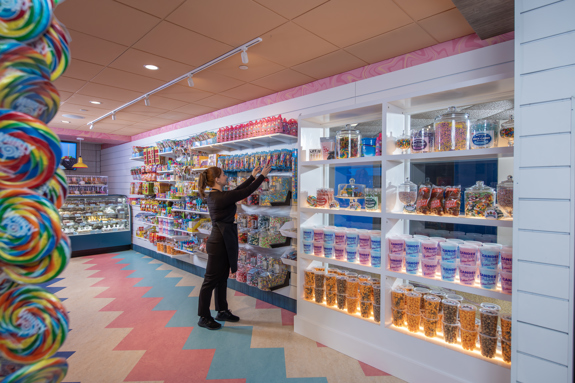 Last bite employee stocking the candy wall
