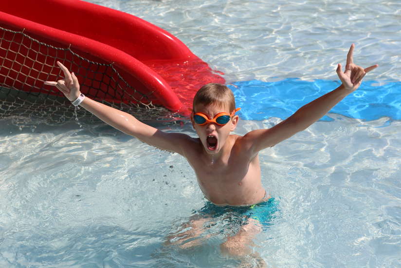 Excited kid in outdoor pool.