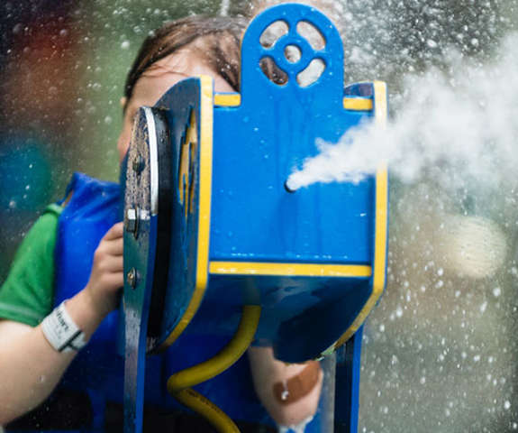 A boy shooting water out of a toy canon.