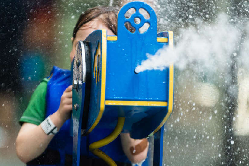 A boy shooting water out of a toy canon.