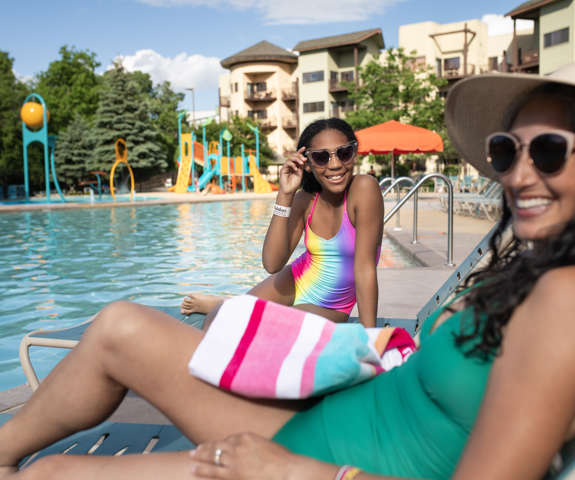 mother and daughter lounging by the pool
