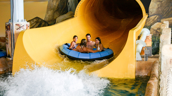 some friends sliding down the victoria falls slide in the indoor waterpark