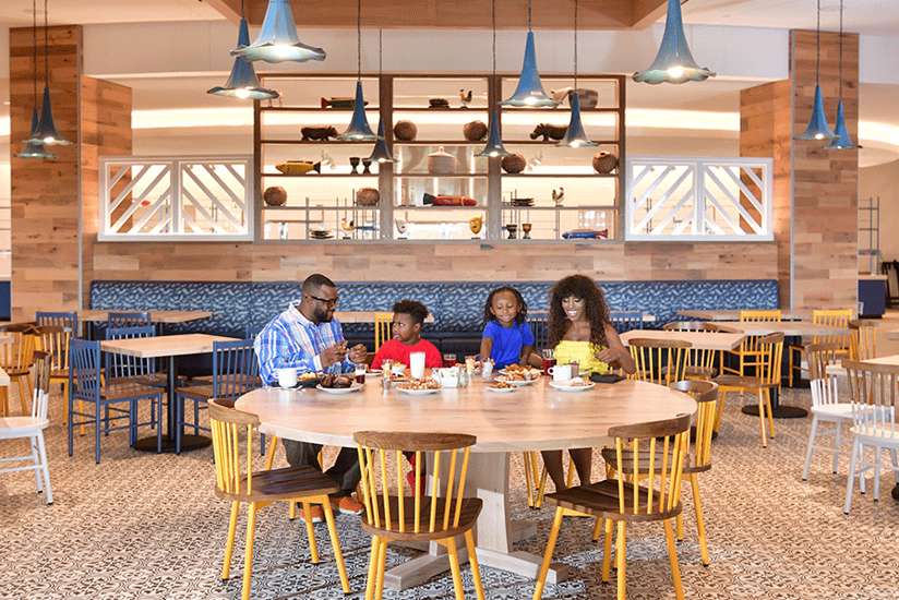 Family dining at a large round table in Great Karoo Marketplace Family dining at a large round table in Great Karoo Marketplace