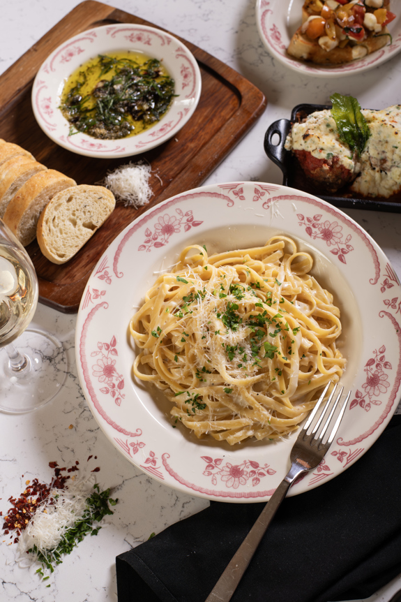 fettuccine pasta & full table of delicious food