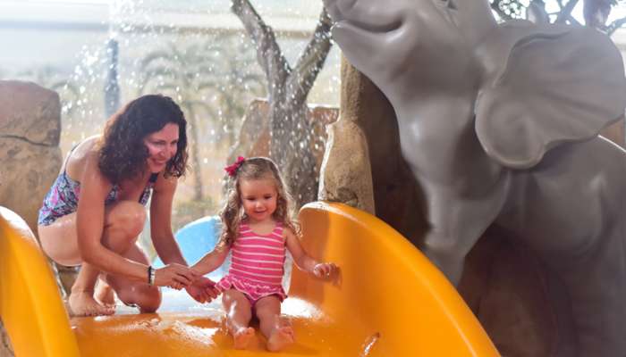 Mom and daughter playing on the slides in Tiko's Watering Hole