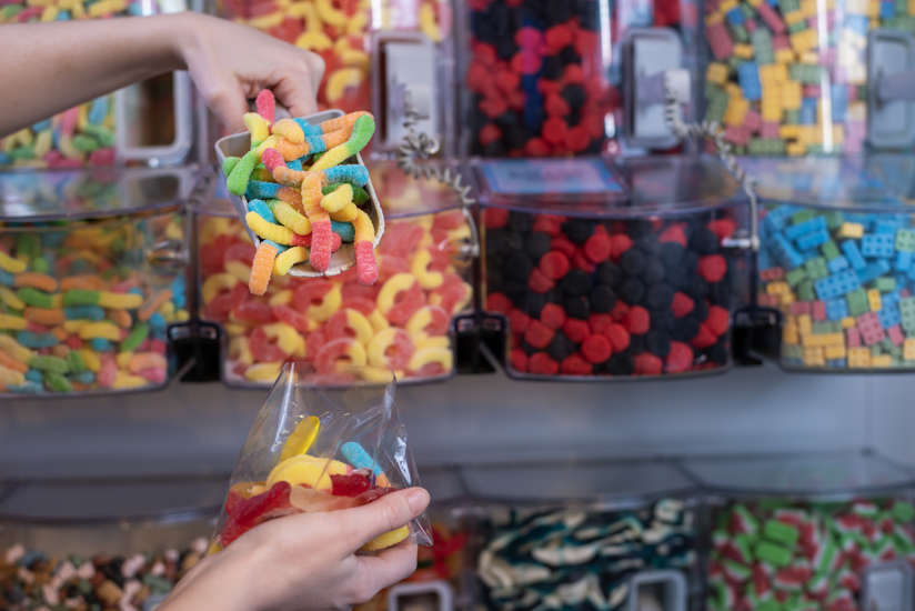 Scooping gummy worms into a treat bag