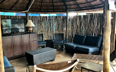 Overview of the upstairs wave cabana. Includes a tv, couches, chairs, and table.