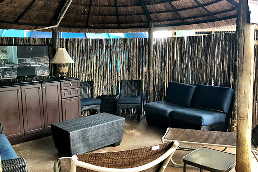 Overview of the upstairs wave cabana. Includes a tv, couches, chairs, and table.