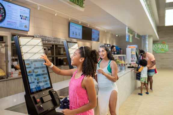 two using kiosks to order kukus chicken