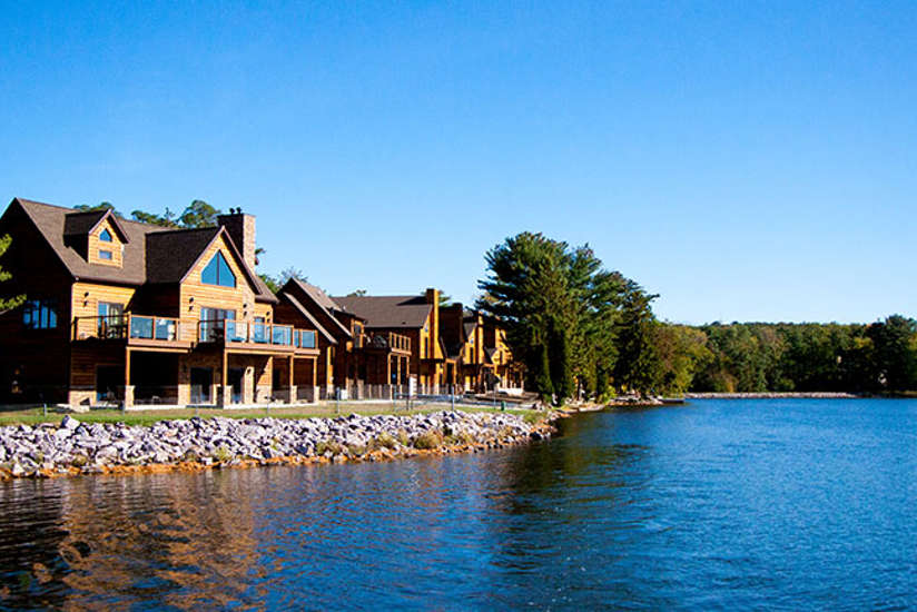 multiple log cabins next to the lake