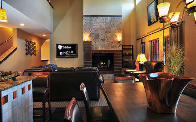 Nyumba Loft living room with a leather couch and chairs surrounding a fireplace