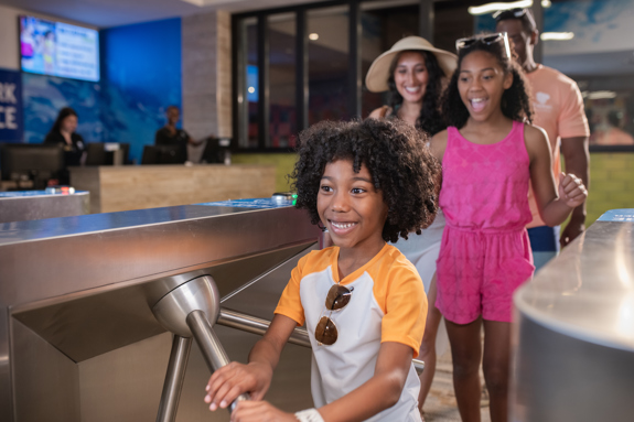 Family entering through turn-style in waterpark